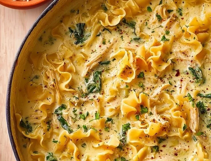 Creamy chicken lasagna soup in a bowl garnished with herbs.