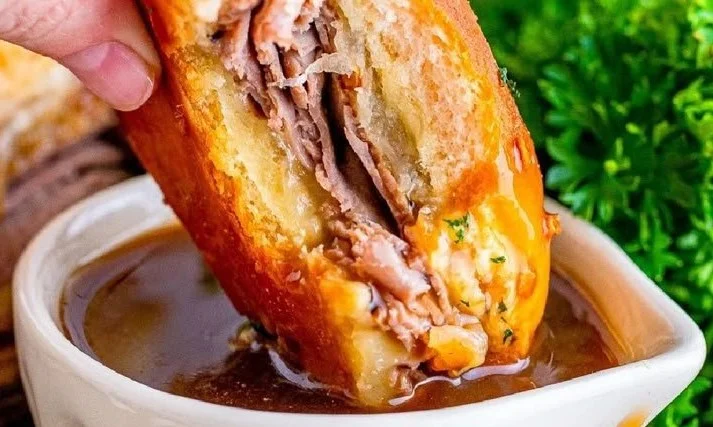 Plated French Dip Sliders with beef and au jus for dipping